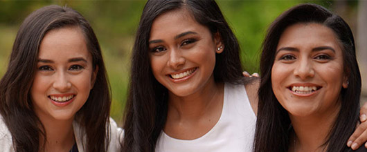 three young adult women smiling